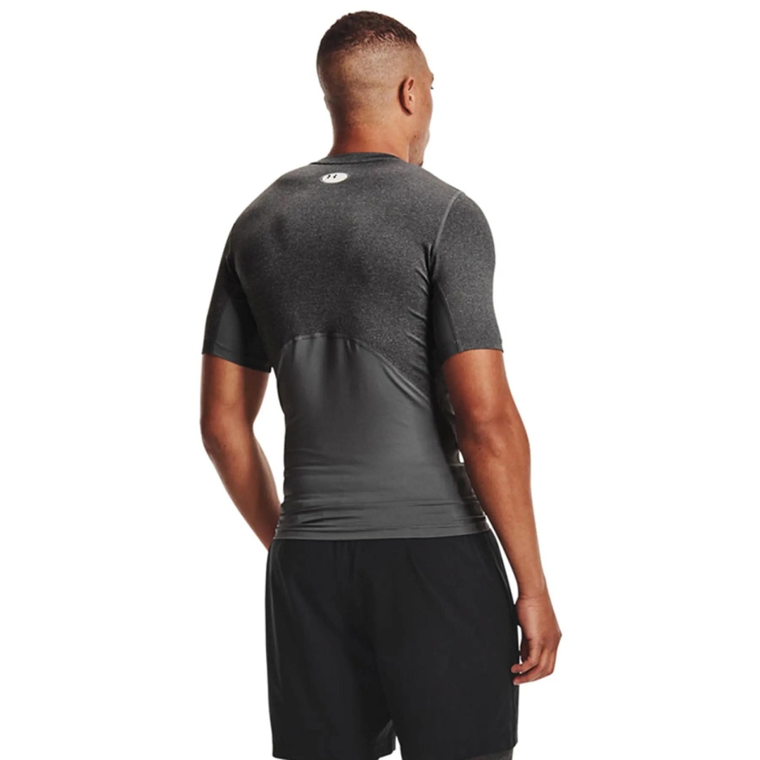t-shirt AJUSTÉ UNDER ARMOUR HEATGEAR ARMOUR POUR HOMME couleur 090-CARBON HEATHER-BLACK porté par un homme vu de dos panneaux en filet visible, manches raglan courtes et éitquette de vestiaire en blanc au haut central