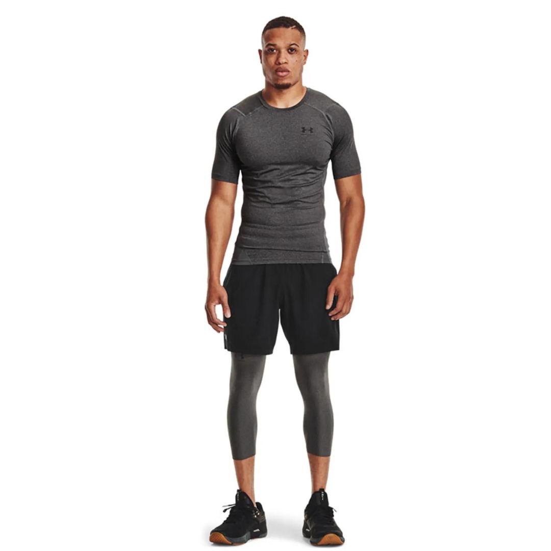 t-shirt AJUSTÉ UNDER ARMOUR HEATGEAR ARMOUR POUR HOMME couleur 090-CARBON HEATHER-BLACK porté par un homme vu de face de la tête aux pieds le t-shirt ajusté retome au haut des hances logo under armour imprimé en noir sur la poitrine gauche du chandail à manches courtes gris charcoal