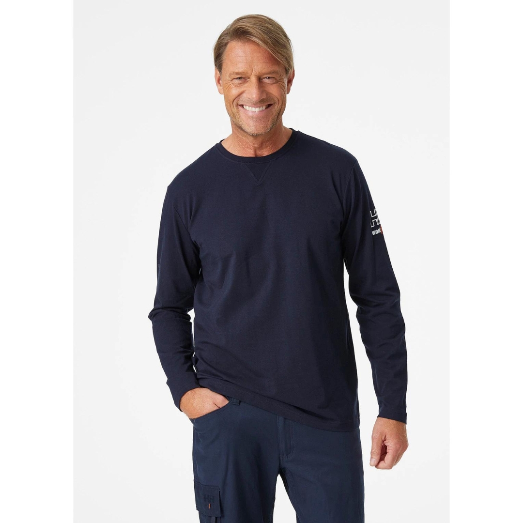 CHANDAIL À MANCHES LONGUES HELLY HANSEN WORKWEAR KENSINGTON POUR HOMME couleur navy porté par un homme vu d face des genoux à la tête logo à la manche droite visible col rond et manches longues