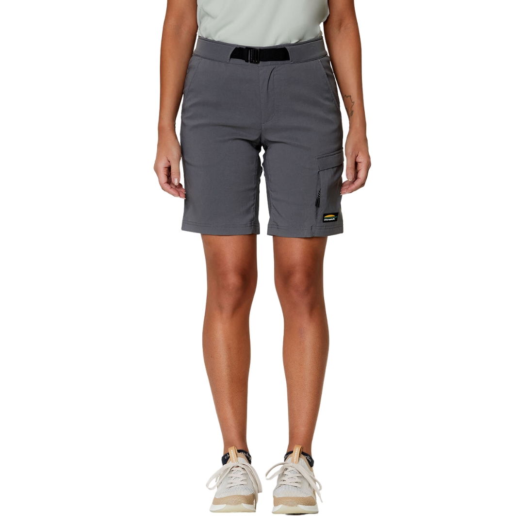 BERMUDA SPORT CHLOROPHYLLE RALLY POUR FEMME COULEUR GRIS PIERRE PORTÉ PAR UNE FEMME VUE DE LA TAILLE AUX PIEDS AVEC LE BERMUDA QUI TOME AU 3/4 DE A CUISSE DE COULEUR GRIS FONCÉ AVEC CEINTURE NOIRE ET LOGO CHLOROPHYLLE SUR LA POCHE CARGO À GAUCHE DU PANTALON COURT