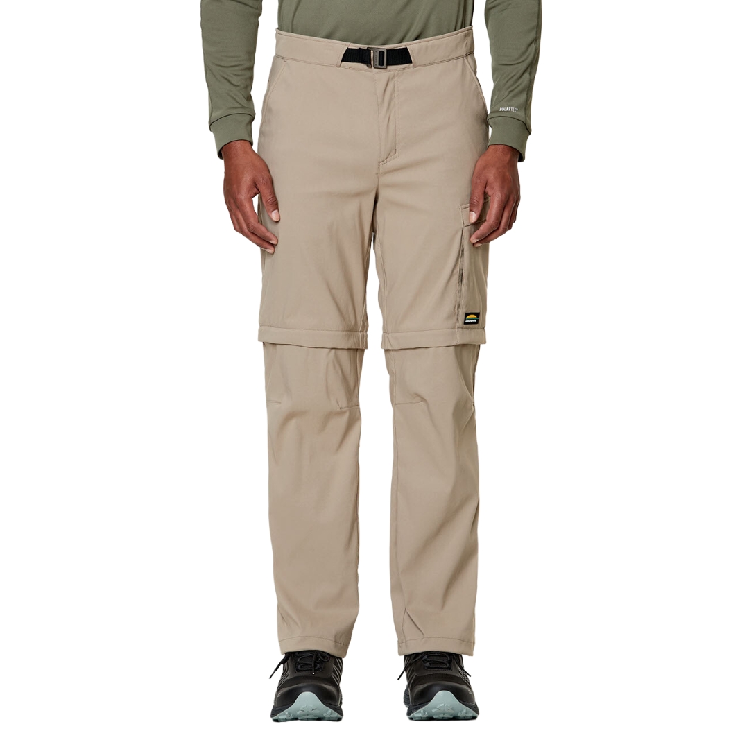 PANTALON DE PLEIN AIR CONVERTIBLE CHLOROPHYLLE RAID POUR HOMME COULEUR ÉRABLE PORTÉ PAR UN HOMME VU DE FACE DE LA TAILLE AUX PIEDS AVEC LE PANTALON BEIGE PALE CEINTURE ET BOUCLE VISIBLE AU HAUT DU PANTALON, POCHE LATÉRALE VISIBLES LOGO CHLOROPHYLLE VISIBLE SUR LA CUISSE GAUCHE