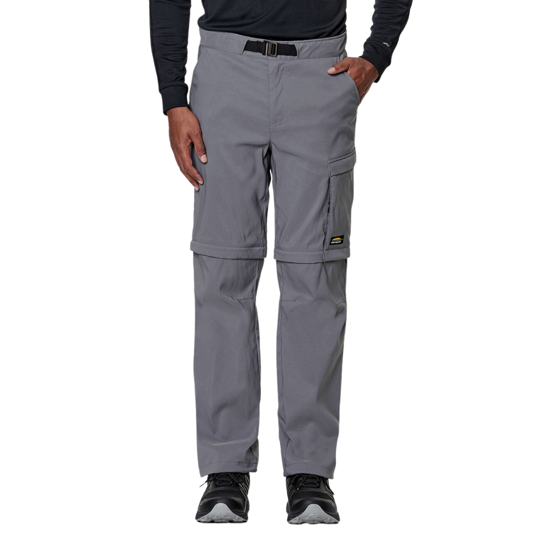 PANTALON DE PLEIN AIR CONVERTIBLE CHLOROPHYLLE RAID POUR HOMME COULEUR GRIS PIERRE PORTÉ PAR UN HOMME VU DE FACE DE LA TAILLE AUX PIEDS AVEC LE PANTALON GRIS PALE CEINTURE ET BOUCLE VISIBLE AU HAUT DU PANTALON L'HOMME A UNE MAIN DANS LA POCHE LATÉRALE LOGO CHLOROPHYLLE VISIBLE SUR LA CUISSE GAUCHE
