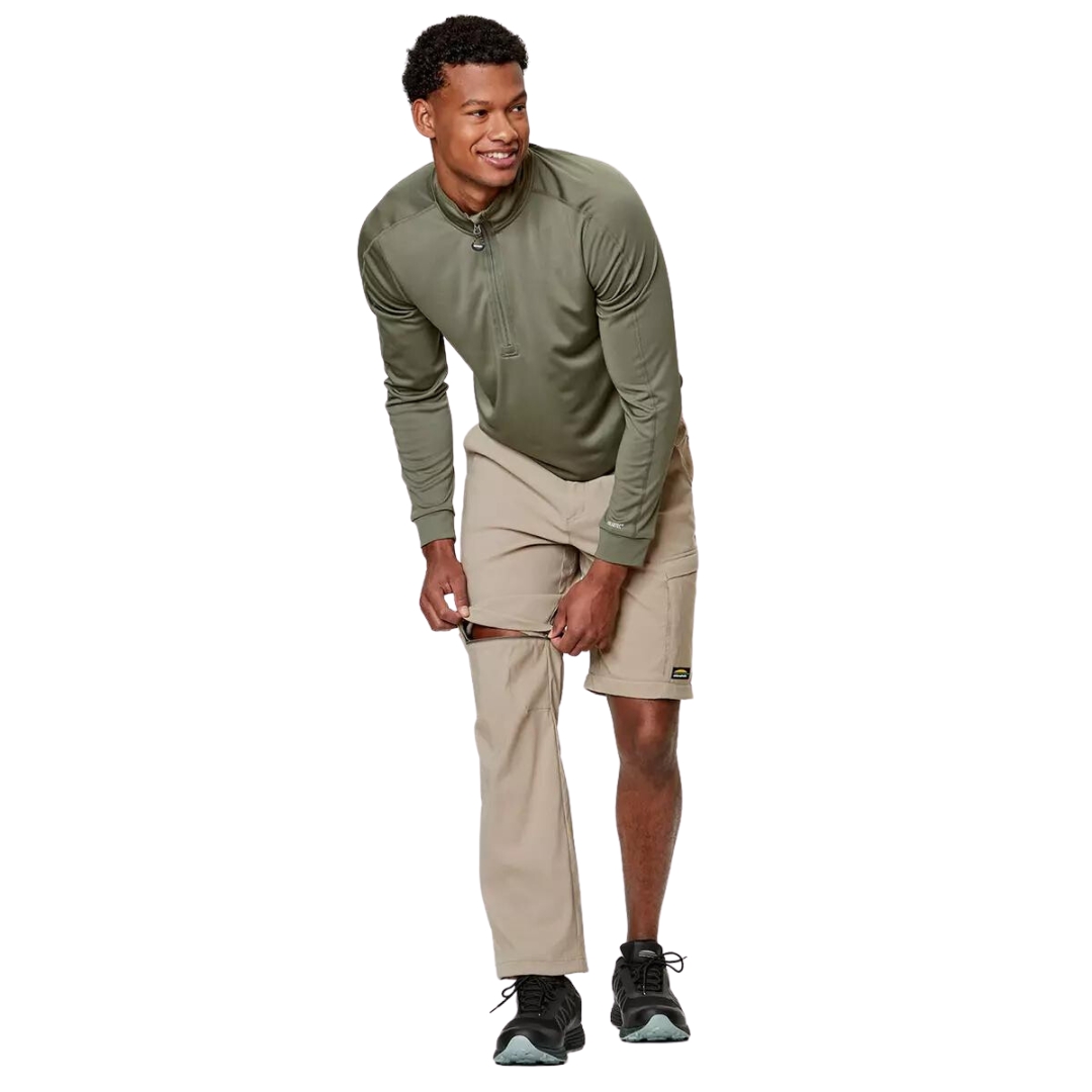 PANTALON DE PLEIN AIR CONVERTIBLE CHLOROPHYLLE RAID POUR HOMME COULEUR ÉRABLE PORTÉ PAR UN HOMME QUI CONVERTI SON PANTALON LONG EN BERMUDA EN OUVRANT LES FERMETURES ÉCLAIRES DU PANTALON BEIGE
