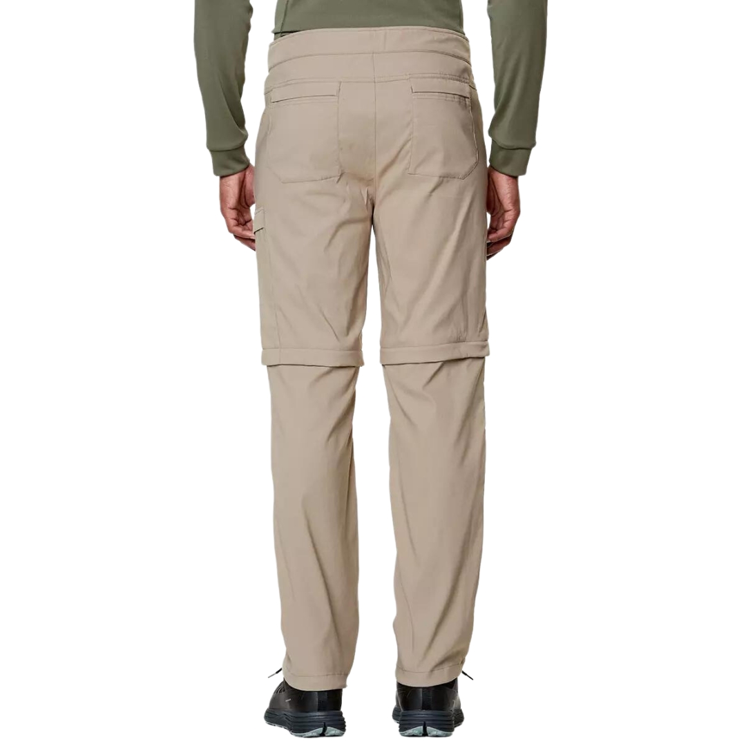 PANTALON DE PLEIN AIR CONVERTIBLE CHLOROPHYLLE RAID POUR HOMME COULEUR ÉRABLE PORTÉ PAR UN HOMME VU DE DOS DE LA TAILLE AUX PIEDS AVEC LE PANTALON BEIGE PALE PORCHES PLAQUÉES AUX FESSES VISIBLE
