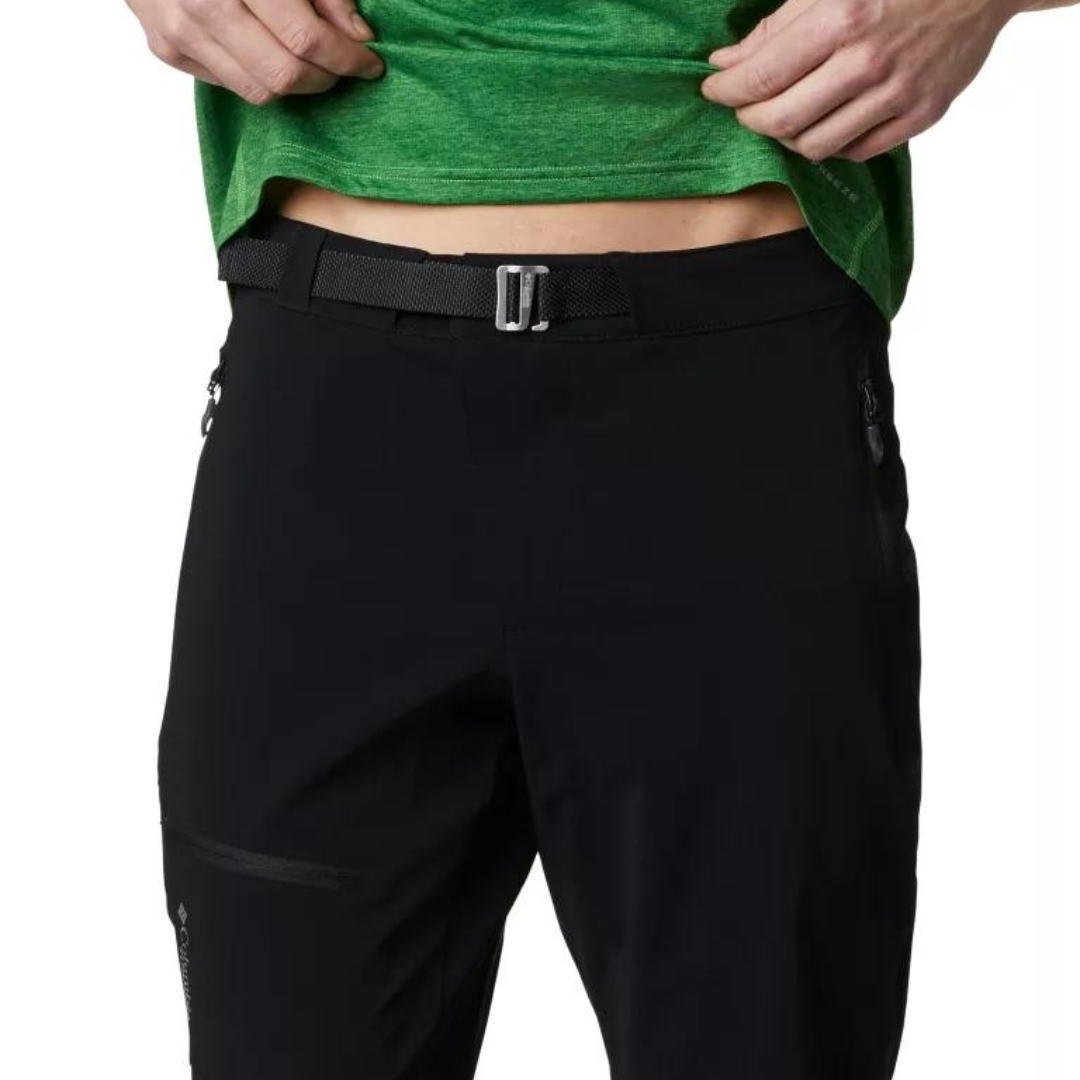 PANTALON DE PLEIN AIR COLUMBIA TITAN PASS POUR HOMME couleur black porté par un homme vu en gros plan sur le haut avant du pantalon avec la ceinture et boucle visibles ainsi que les fermeuture éclair des poches latérales