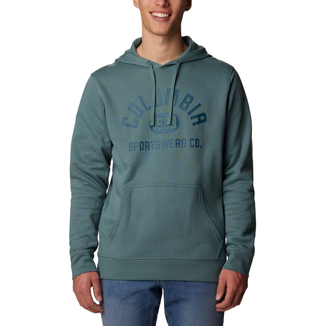 CHANDAIL À CAPUCHON COLUMBIA TREK POUR HOMME couleur 347-METAL/COLLEGE LIFE GRAPHIC porté par un homme vu de face logo columbia imprimé en géant au devant, poche kangourou visible, cordon de serrage de la capuche visibles également