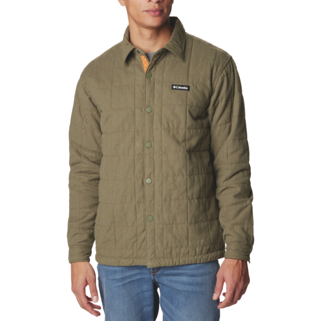 CHEMISE MATELASSÉE COLUMBIA LANDROAMER POUR HOMME couleur 397-stone green porté par un homme vu de face avec la chemise boutonnée verte olive qui retombe aux hanches avec un écusson columbia cousu à la poitrine gauche