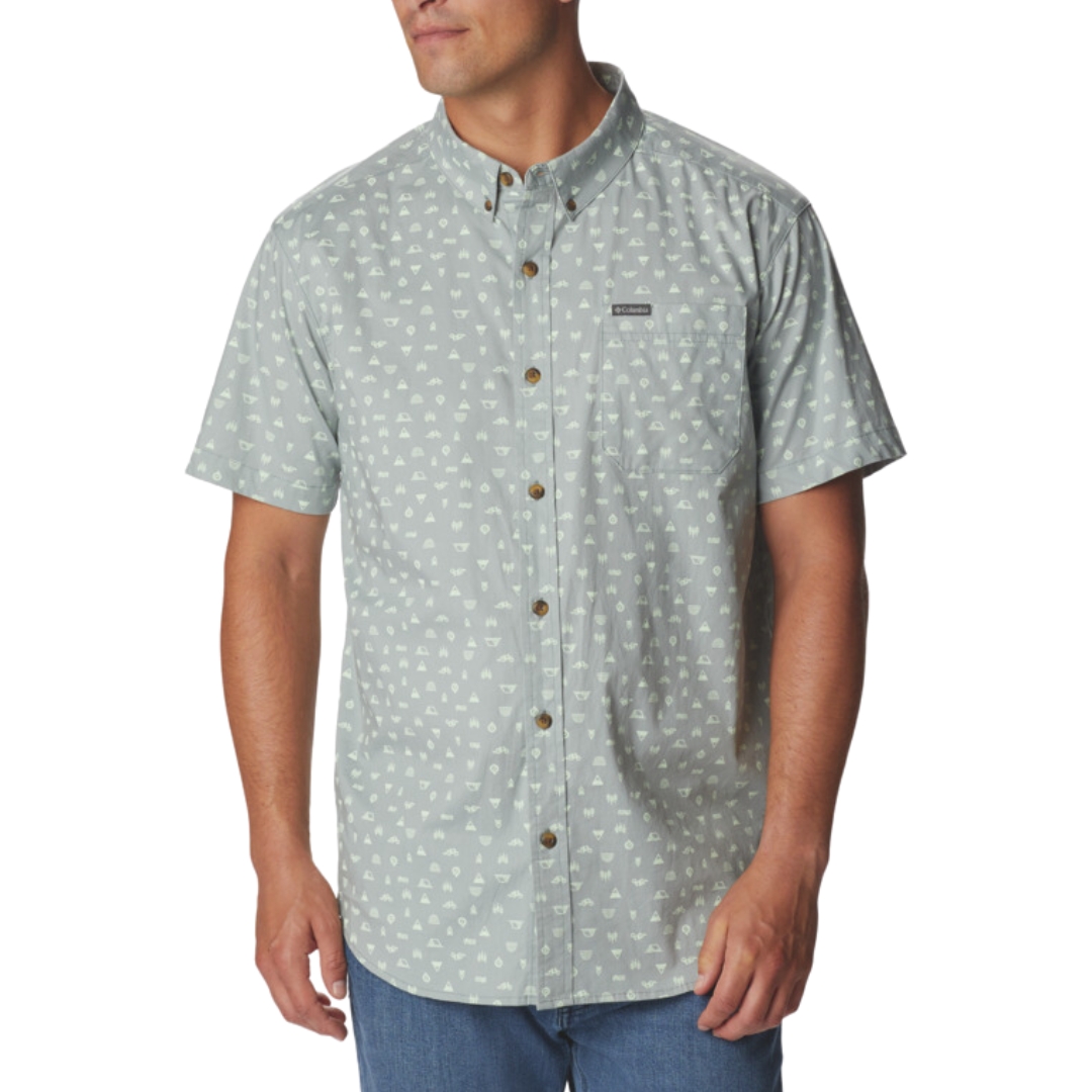 CHEMISE À MANCHES COURTES COLUMBIA RAPID RIVERS PRINTED POUR HOMME COULEUR 346-METAL CAMP ICON PORTÉ PAR UN HOMME VU DE FACE AVEC LA CHEMISE BLEUE GRISE À IMPRIMÉ à motifs de camp couleur blanc/gris manches courtes patte boutonnée