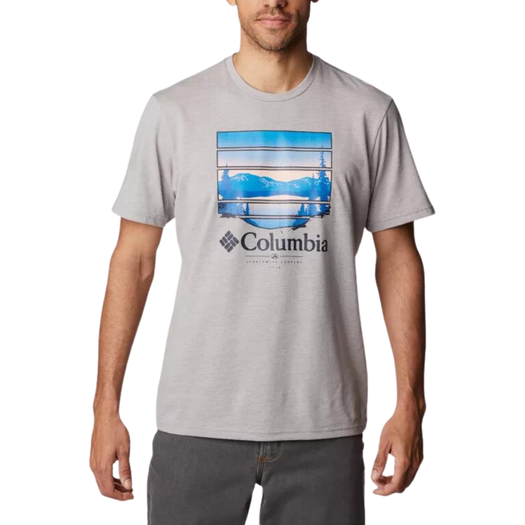 T-SHIRT À MANCHES COURTES COLUMBIA PATH LAKE GRAPHIC II POUR HOMME COULEUR 042-COLUMBIA GREY HEATHER PORTÉ PAR UN HOMME VU DE FACE DE LA TÊTE AUX CUISSES CHANDAIL GRIS PALE AVEC GRAPHIQUE GÉANT AU DEVANT REPRÉSENTANT UN LAC, MONTAGNES ET ARBRE DANS LES TONS DE BLEU ET PÊCHE AVEC LE NOM COLUMBIA EN DESSOUS DU GRAPHIQUE