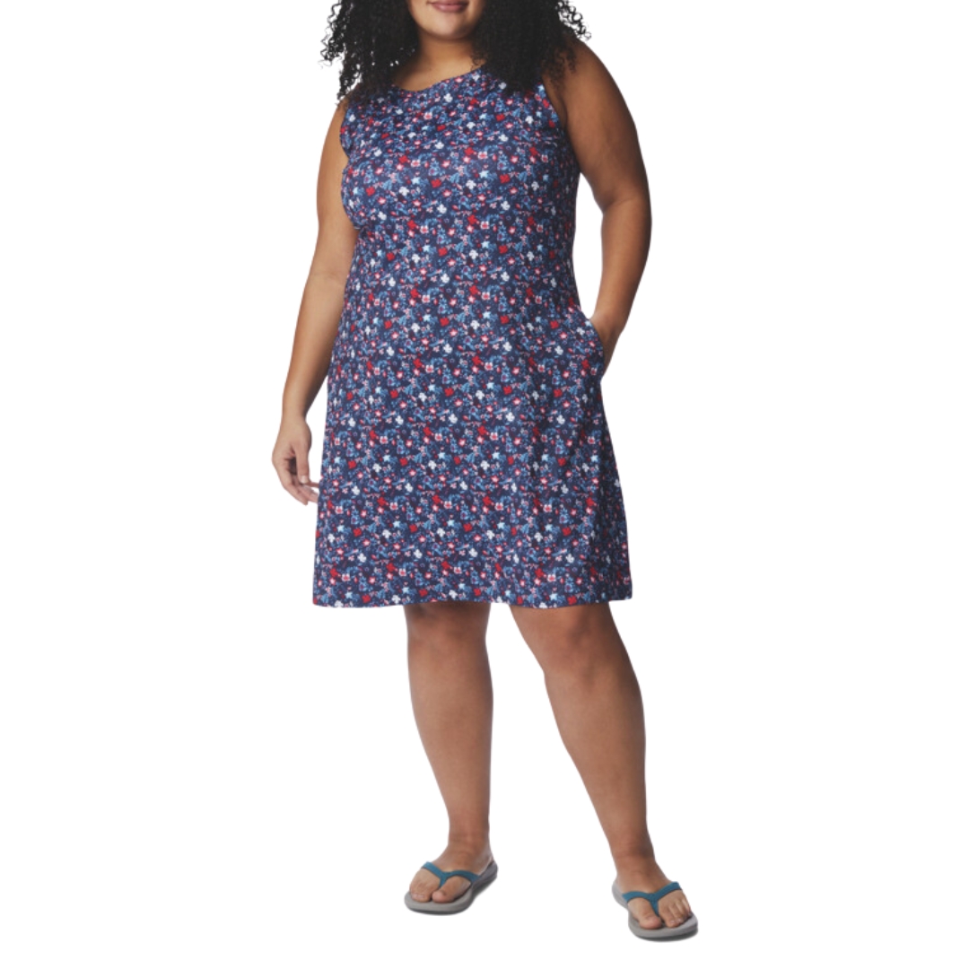 ROBE IMPRIMÉE COLUMBIA CHILL RIVER POUR FEMME GRANDES TAILLES 461-NOCTURNAL/ MINI HIBISCUS PORTÉE PAR UNE FEMME VUE DE FACE DE LA TÊTE AUX PIEDS, ROBE MARINE AVEC IMPRIMÉS FLEURIS EN ROUGE ET DÉGRADÉS DE BLEU, LA ROBE TOMBE AU GENOUX, SANS MANCHES ET COL ROND