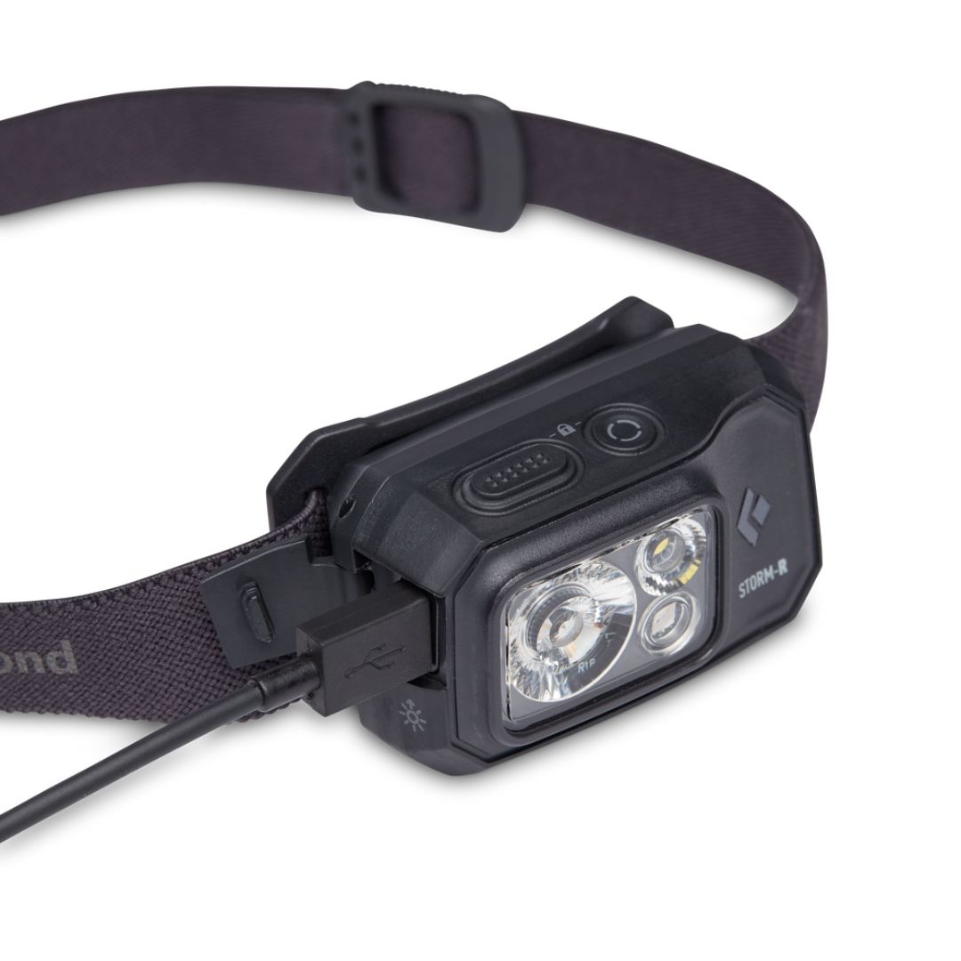 LAMPE FRONTALE BLACK DIAMOND STORM 500 RECHARGEABLE COULEUR BLACK VUE DE PROFIL GAUCHE DU BOITIER NOIR DE LA LAMPE, CELLE CI EST BRANCHÉ À SON FIL DE CHARGEMENT
