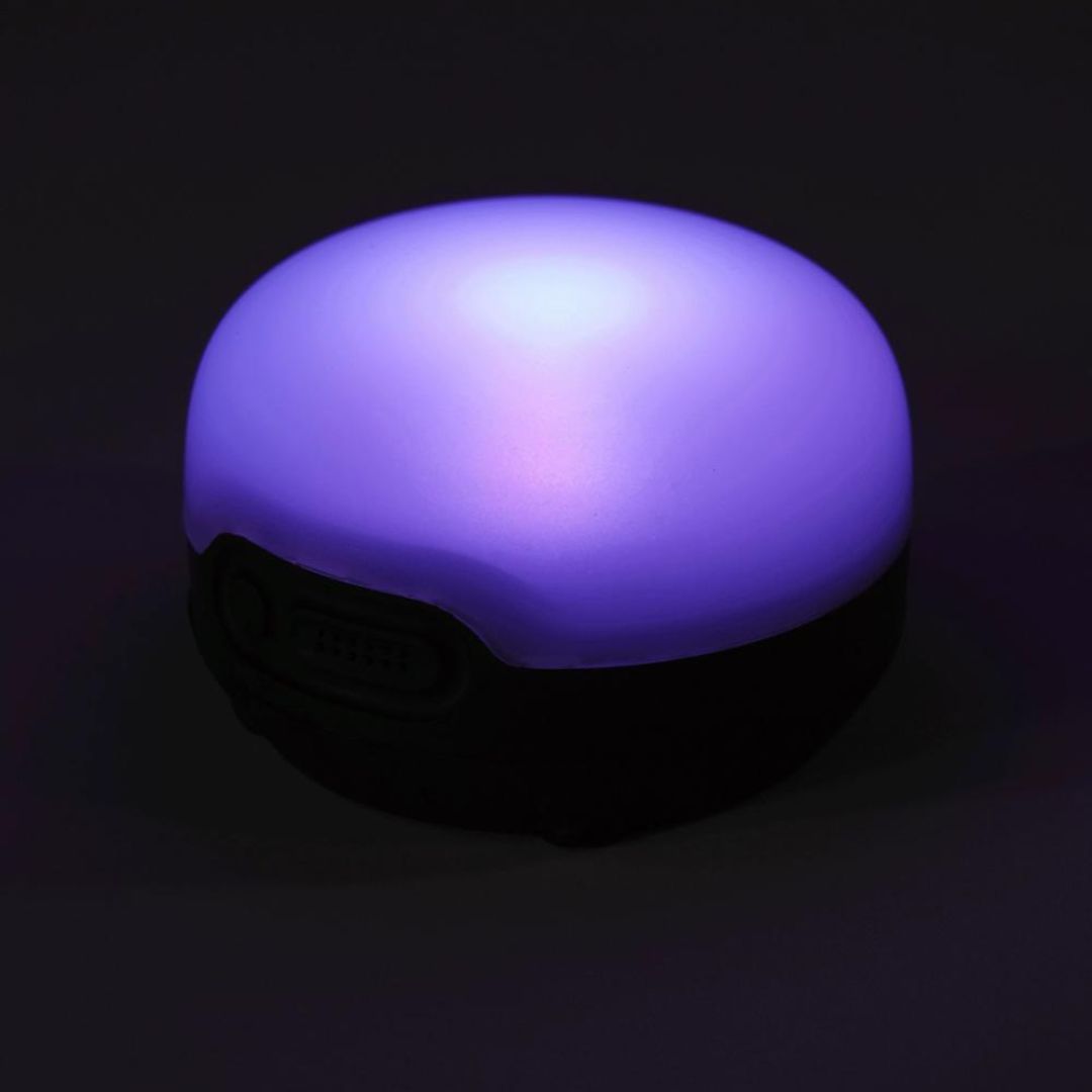 LANTERNE BLACK DIAMOND MOJI+ RECHARGEABLE vue de la lanterne dans la pénombre, elle est allumée en violet, toute la partie du dessus est lumineuse