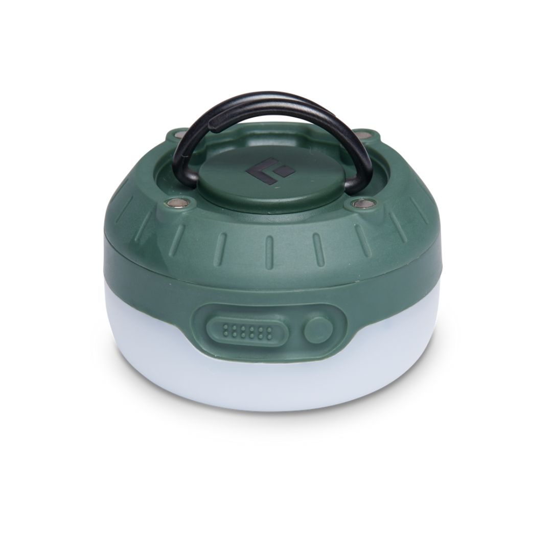 LANTERNE BLACK DIAMOND MOJI+ RECHARGEABLE couleur Dark Laurel vue de la lanterne du dessous avant, on voit les boutons de controle sur la base verte laurier de la lanterne. son dessus est blanc, le logo Black Diamond est au centre de la base en noir et on voit les poignée de la lanterne qui sont relevées au dessus de la lanterne