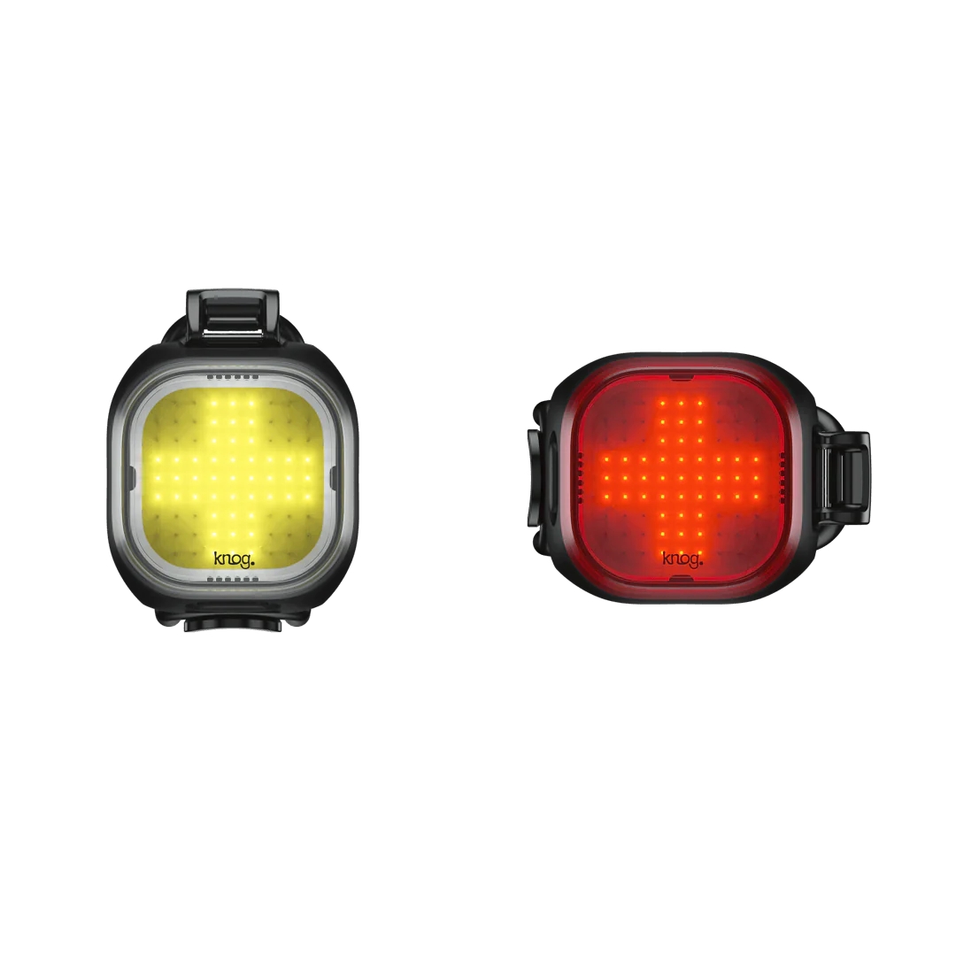 MINI PHARE POUR VÉLO KNOG BLINDER TWINPACK vue du devant des deux phares, on voit le motif en croix des leds à l'intérieure, la lumière avant est à gauche et est de couleur jaune, tandis que la lumière arrière est à droite et est de couleur rouge