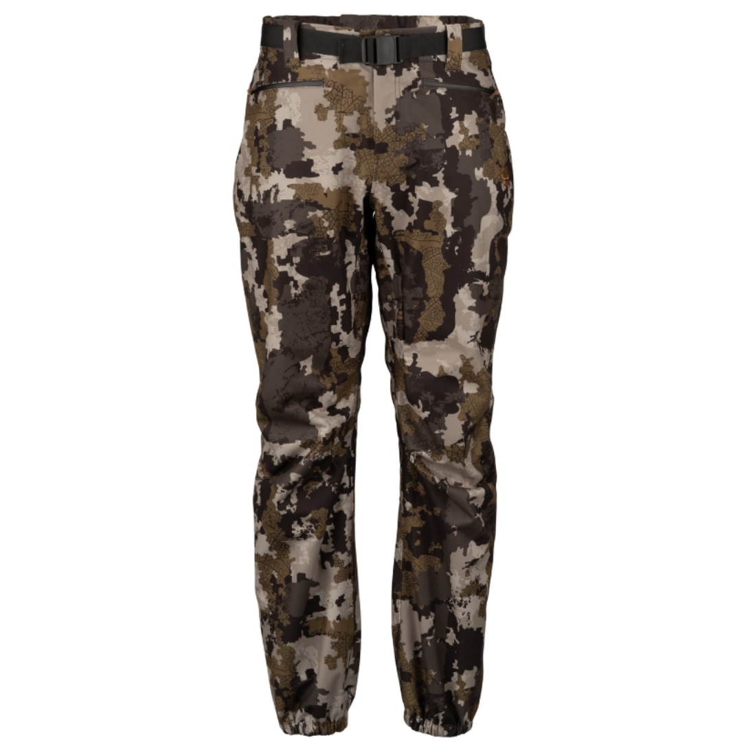 Le pantalon Connec Outdoors Slikke || est l'imperméable le plus polyvalent, permissif et adapté pour nos chasses d'ici. Conçu pour résister des heures aux intempéries en chasse il est très léger et prend peu d'espace dans un sac. La membrane microporeuse imperméable et coupe-vent eVent Technology utilisée dans la construction du pantalon Slikke II empêche l'eau de pluie de pénétrer et permet à l'humidité de sortir par ses microspores. Le Slikke possède des Fermetures Éclair scellées et imperméables. Les coutures du pantalon sont chevauchées et scellées avec l'adhésif le plus étanche de l'industrie. Le devant de la jambe est une mono-pièce pratiquement sans coutures afin de limiter les infiltrations potentielles. Il possède une pré-articulation au niveau des genoux et des fesses afin de permettre une plus grande liberté de mouvement. Le pantalon Slikke possède deux poches profondes au haut à fermetures Éclair scellées et imperméable. Les coutures du pantalon sont chevauchées et scellées avec l'adhésif le plus étanche de l'industrie. Il possède un ajustement aux chevilles à fermeture éclair scellé afin de le porter avec différents types / grosseurs de bottes. L'ajustement et son élastique au bas permettent non seulement de le sceller contre l'eau avec la botte, mais sont aussi conçus pour amincir le bas du pantalon et éviter un surplus de matière qui pourrait causer un bruit de frottement de tissus ou de l'usure à long terme. Son crochet au bas du devant sert à attacher le pantalon sur les lacets pour le tenir en place. Couleur camo brun, beige et vert forest. Petit logo Connec orange du côté gauche du pantalon.