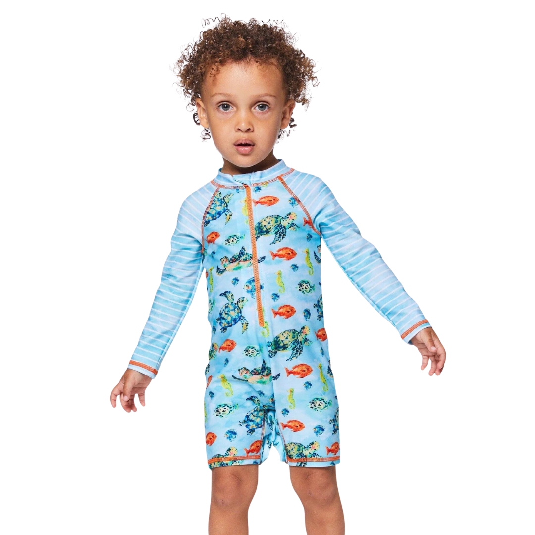 MAILLOT DE BAIN UNE PIÈCE DEUX PAR DEUX RASHGUARD MANCHES LONGUES POUR BÉBÉ GARÇON couleur fish vu du maillot bleu ciel à imprimé tortue/poisson porté par un petit garçon vu de face