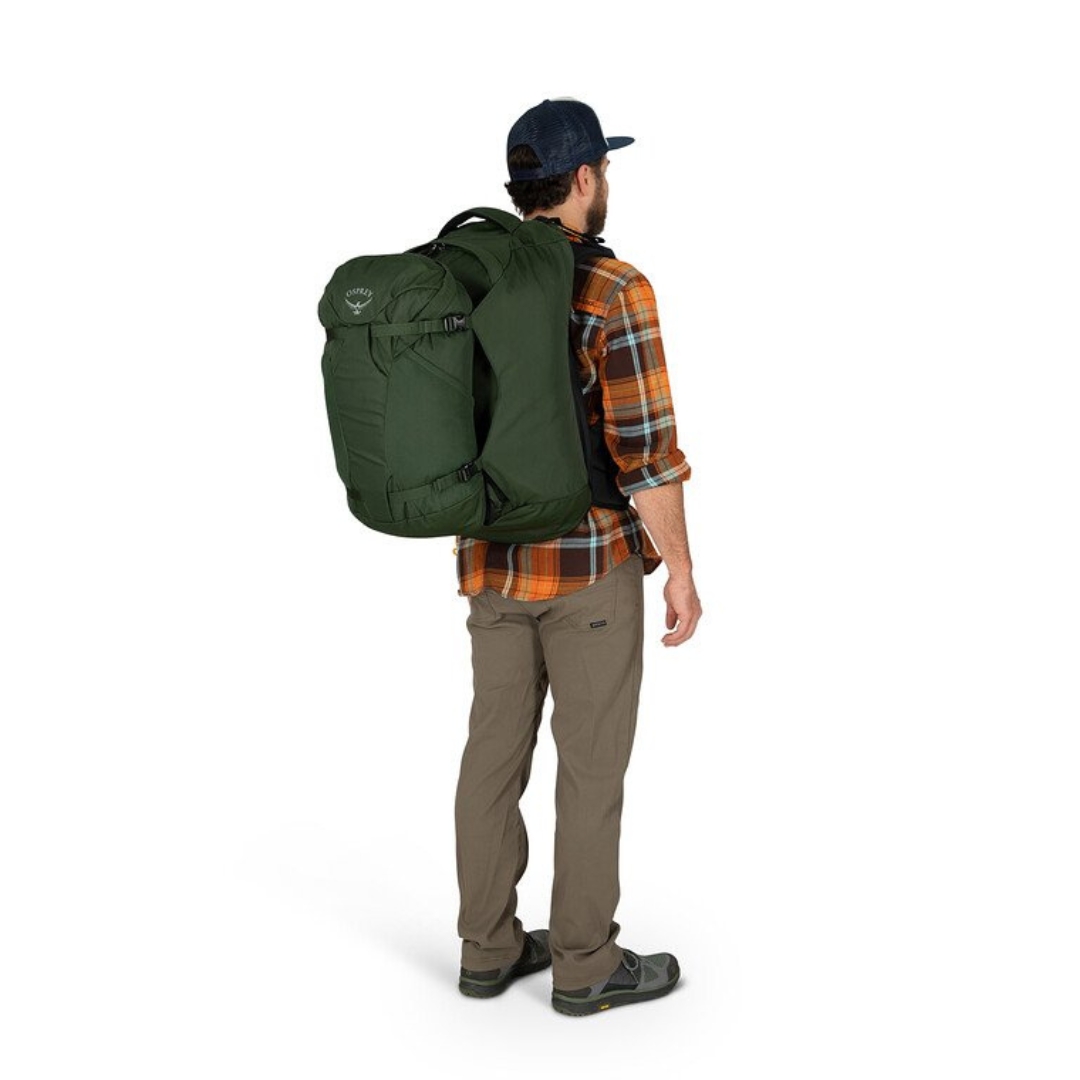 SAC DE VOYAGE OSPREY FARPOINT 55 POUR HOMME PORTÉ PAR UN HOMME VU DE PROFIL ARRIÈRE DROIT