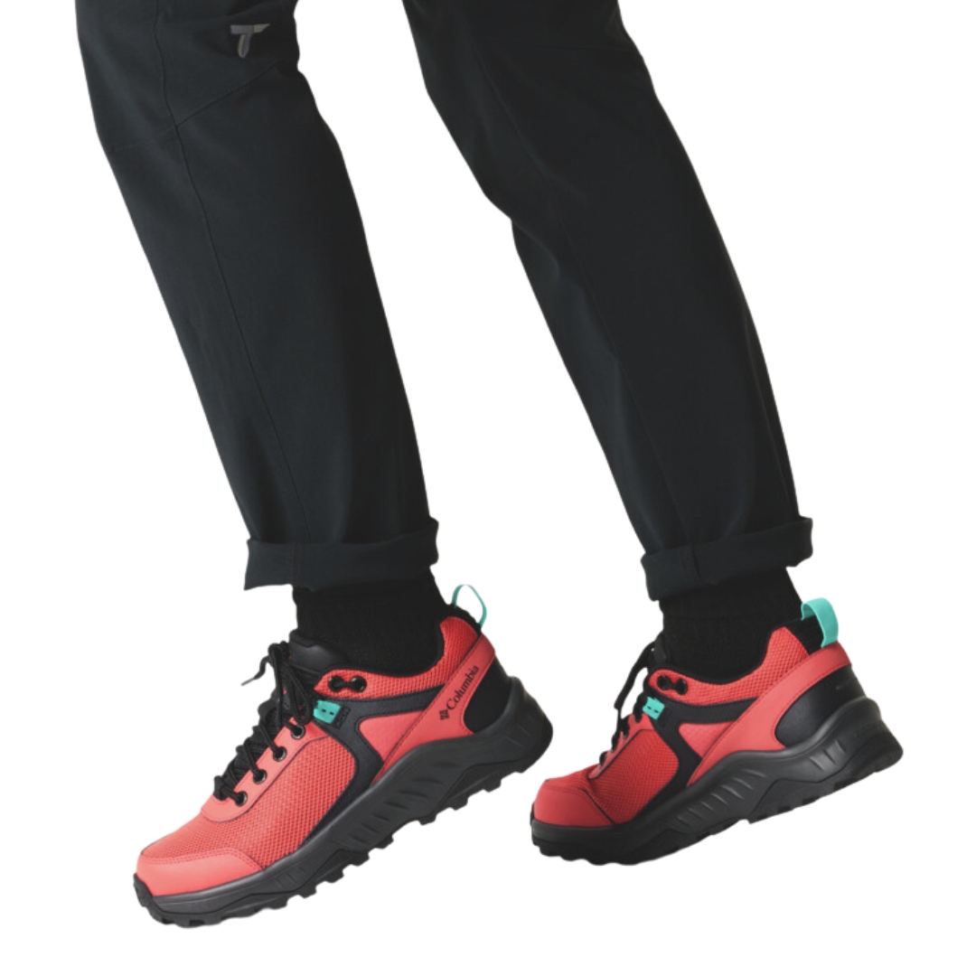 chaussure DE RANDONNÉ IMPERMÉABLE COLUMBIA TRAILSTORM ASCEND MID PIED LARGE POUR FEMME COULEUR 633-RED CORAL/BRIGHT AQUA VU DE la chaussure droite couleur corail et noir avec détails bleux aqua porté par une femme vue de profi gauche