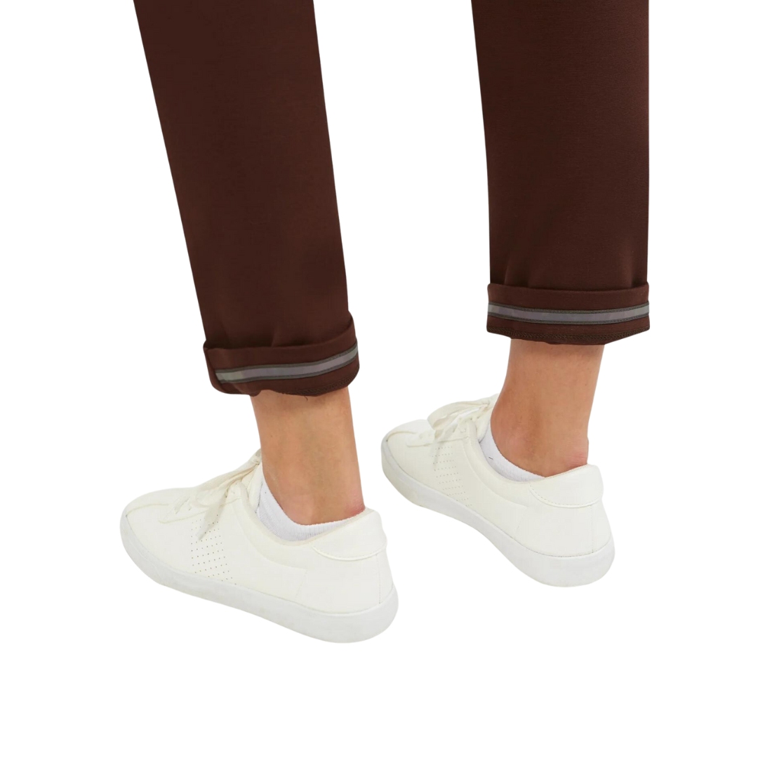 PANTALON À LA CHEVILLE FIG ST-JAMES POUR FEMME couleur coffee vu du pantalon brun/rouge porté par une femme vue en gros plan sur l'ourlet inversé à détail réfléchissants
