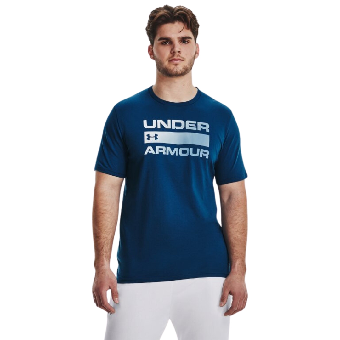 CHANDAIL À MANCHES COURTES UNDER ARMOUR TEAM ISSUE WOODMARK POUR HOMME COULEUR 426-VARSITY BLUE VU DU CHANDAIL BLEU FONCÉ LÉTTRÉ BLANC DÉGRADÉ BLEU PORTÉ PAR UN HOMME VU DE FACE DE LA TÊTE AUX CUISSES