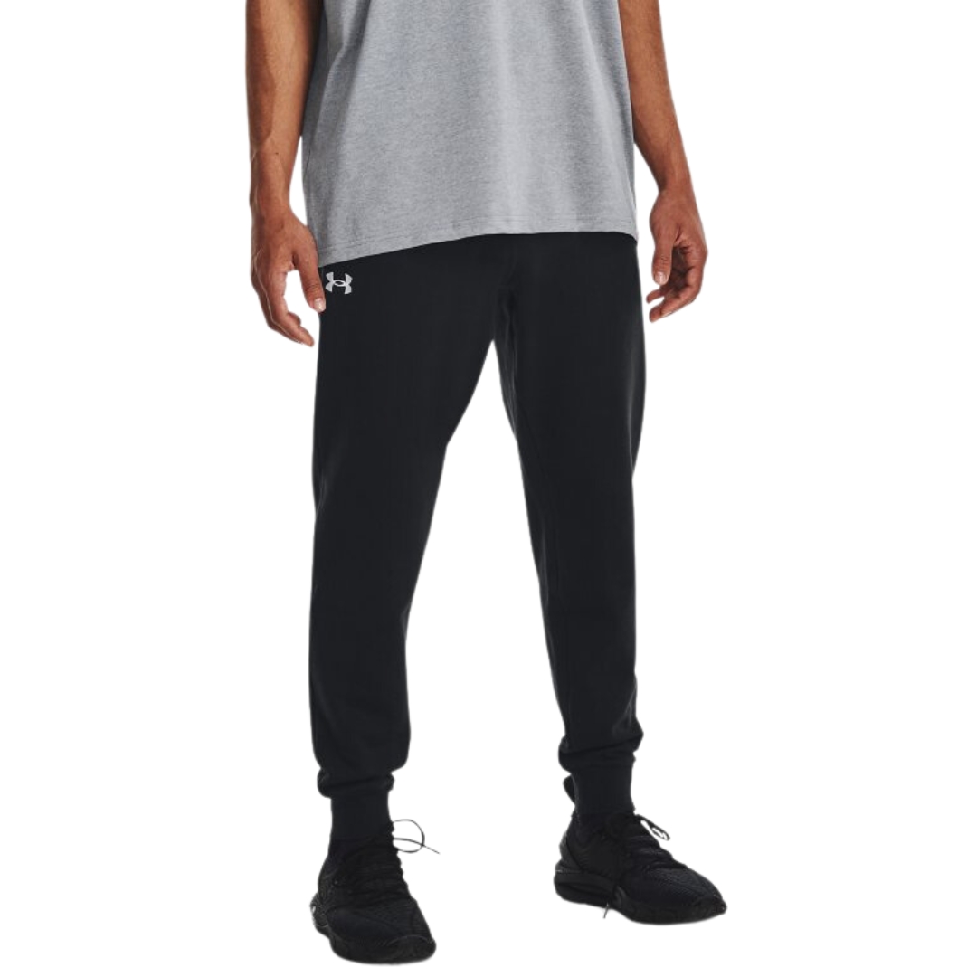 PANTALON LONG DE JOGGING UNDER ARMOUR UA RIVAL POUR HOMME COULEUR 001-BLACK/WHITE VU DU PANTALON NOIR LETTRÉ BLANC PORTÉ PAR UN HOMME VU DE LA POITRINE AUX PIEDS DE FACE