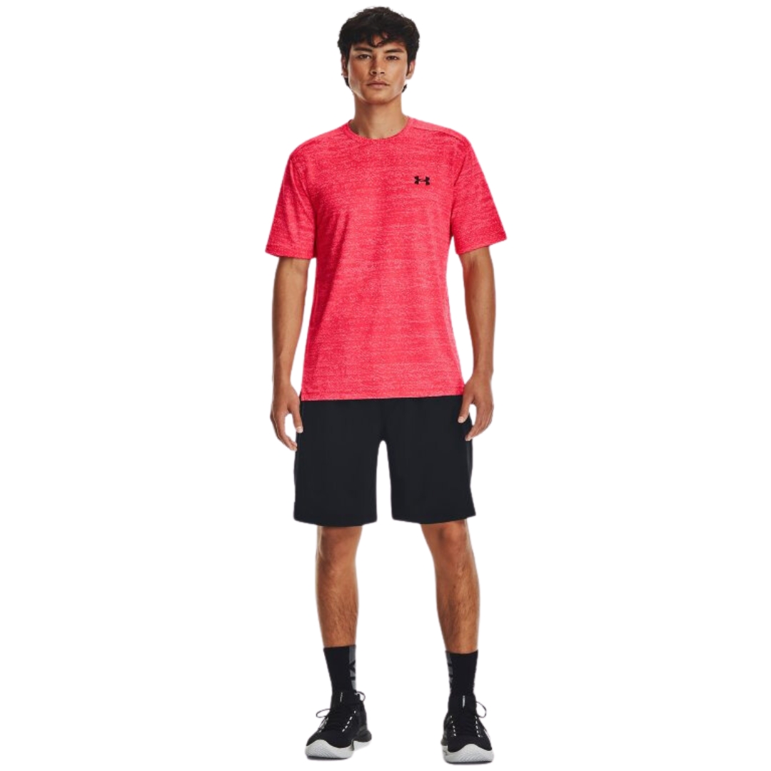 T-SHIRT D'ENTRAINEMENT EN JACQUARD UNDER ARMOUR UA TECH VENT POUR HOMME couleur 628-BETA/BLACK vu du chandail à manches courtes de couleur orange/rose flash lettré noir porté par un homme vu de la tête aux pieds de face