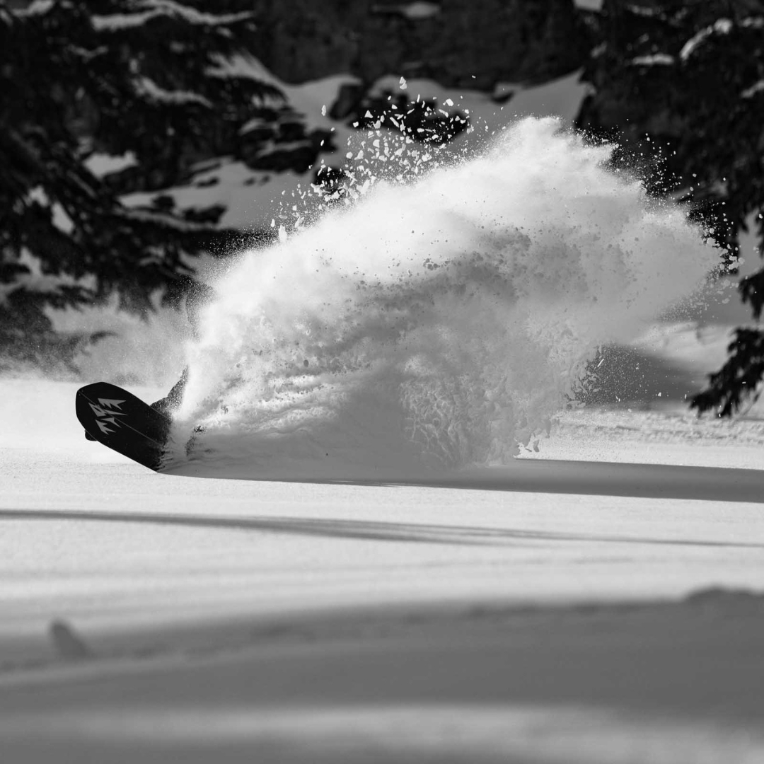 SPLITBOARD JONES STRATOS POUR HOMME vu de la planche blanche lignée rouge et noire utilisé par un homme dans la poudreuse