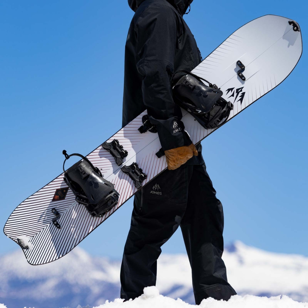 SPLITBOARD JONES STRATOS POUR HOMME vu de la planche blanche lignée rouge et noire porté à la main par un homme vu de profil