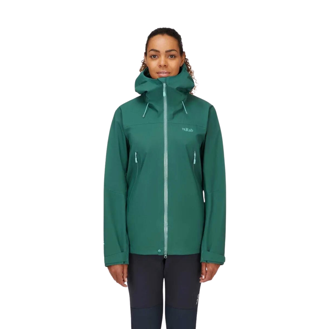 COQUILLE RAB KANGRI GORE-TEX POUR FEMME COULEUR GREEN SLATE VU DU MANTEAU VERT EMERAUDE AVEC DÉTAI VERT MENTHE PORTÉ PAR UNE FEMME VUE DE LA TÊTE AUX CUISSES DE FACE