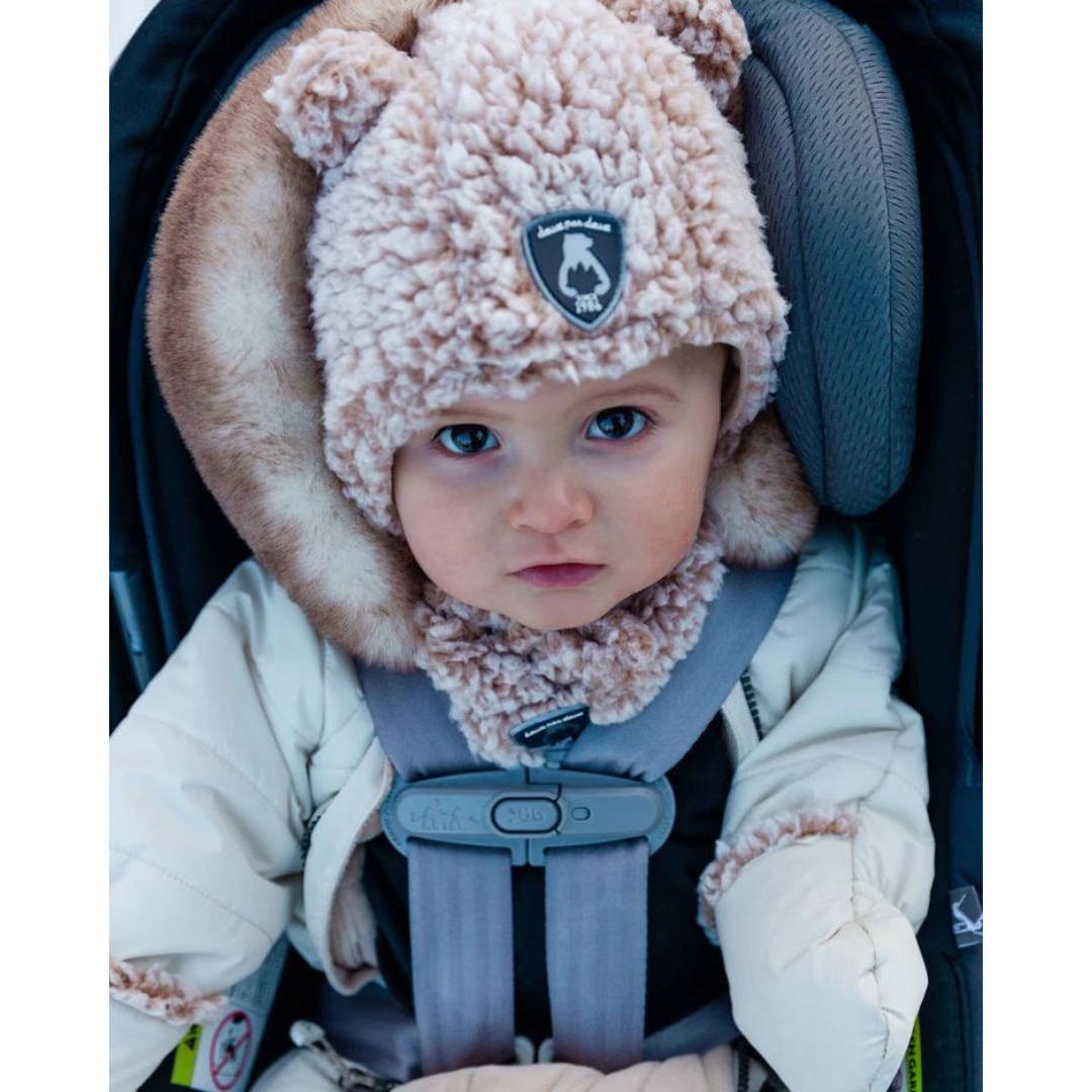 TUQUE EN SHERPA DEUX PAR DEUX AVEC OREILLES POUR BÉBÉ couleur whisper white vu du chapeau brun ocre chiné porté par un bébé dans un siège de voiture