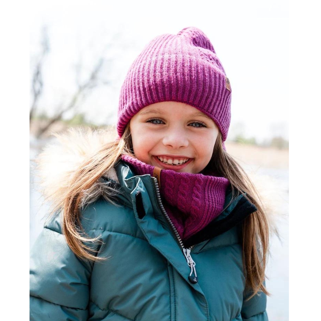 TUQUE EN TRICOT DEUX PAR DEUX POUR ENFANT couleur DAMSON vue de la tuque rose fuschia portée par une fille dehors