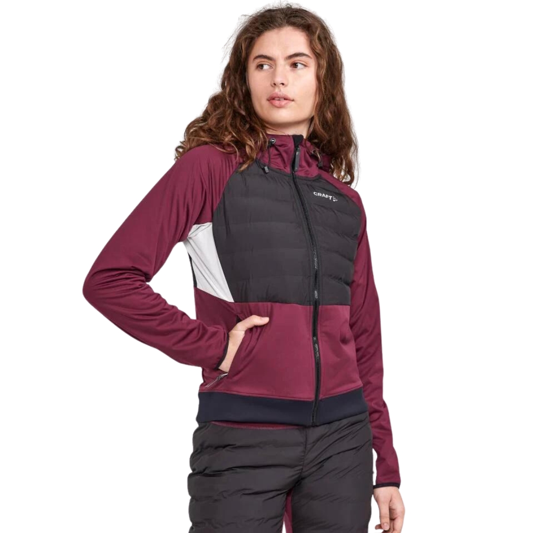 MANTEAU DE SKI DE FOND CRAFT ADV PURSUIT THERMAL POUR FEMME COULEUR PUNSCH/BLACK VU DU MANTEAU ROUGE BOURGOGNE, NOIR ET BLANC PORTÉ PAR UNE FEMME VUE DE FACE DE LA TÊTE AUX CUISSES