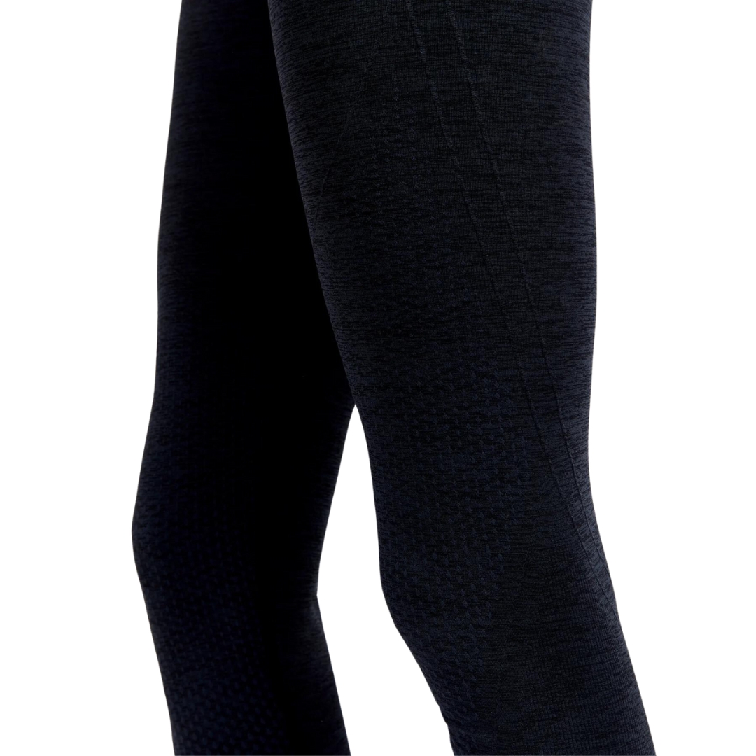 CALEÇON LONG D'ENTRAINEMENT CRAFT CORE DRY ACTIVE COMFORT POUR FEMME COULEUR BLACK VU DU COLLANT NOIR PORTÉ PAR UNE FEMME VUE DE PROFIL EN GROS PLAN SUR LES GENOUS