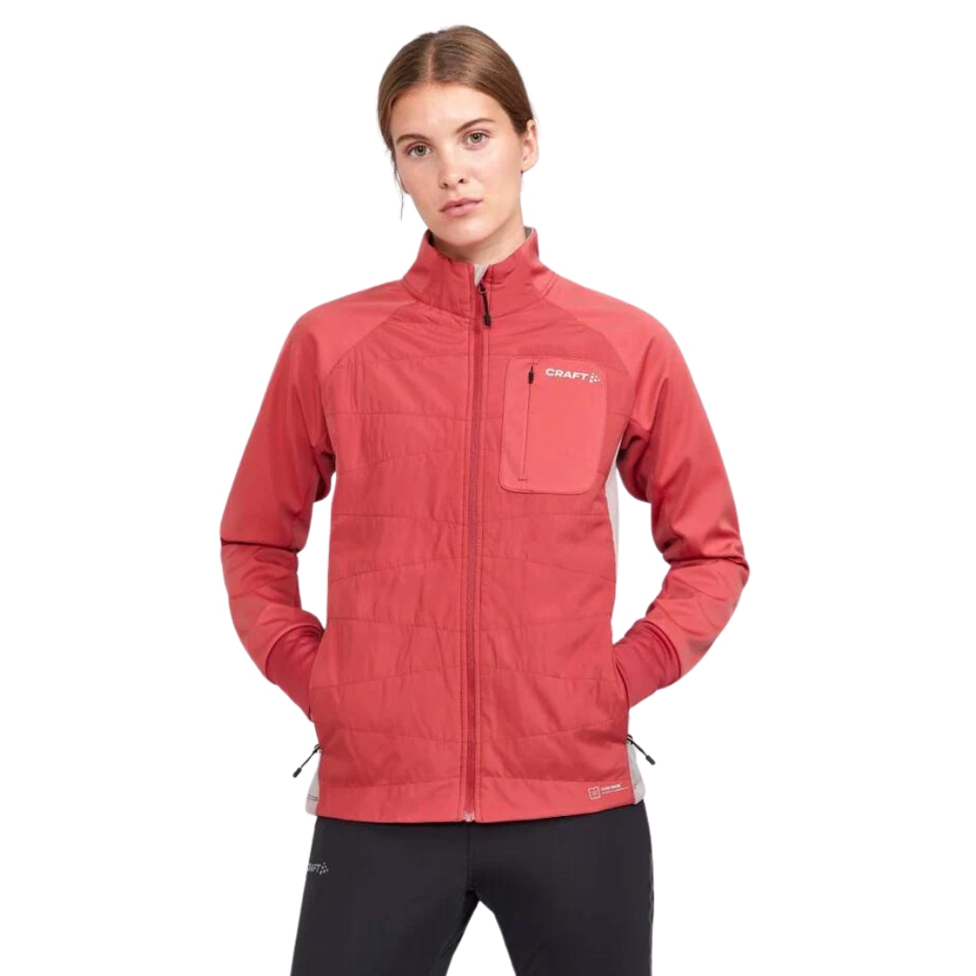 MANTEAU ISOLÉ DE SKI DE FOND CRAFT CORE NORDIC TRAINING INSULATE POUR FEMME COULEUR ASTRO/CLAY VU DU MANTEAU ORANGE CORAIL ET BEIGE SABLE PORTÉ PAR UNE FEMME VUE DE LA TÊTE AUX CUISSES DE FACE