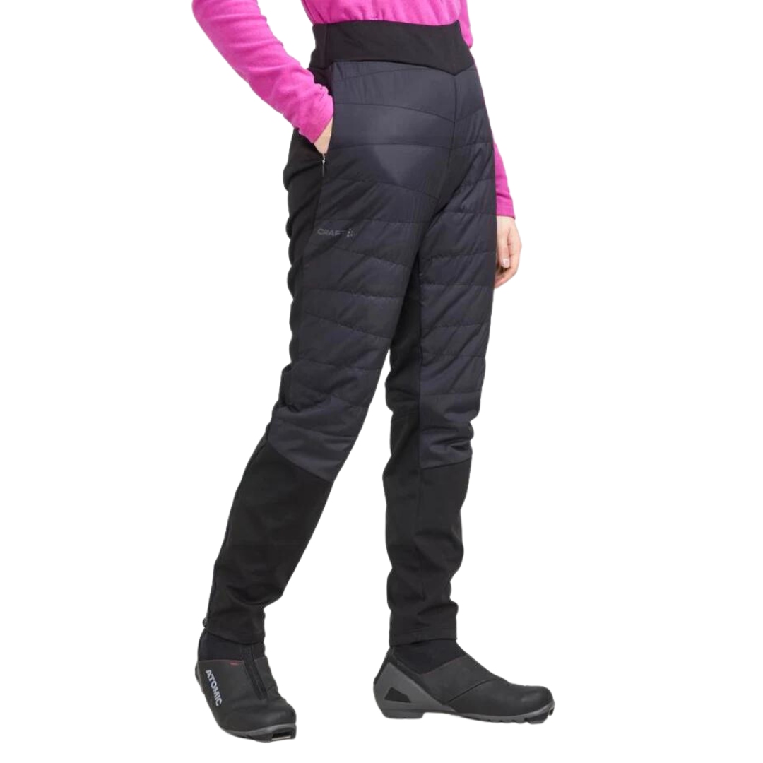 PANTALON ISOLÉ DE SKI DE FOND CRAFT CORE NORDIC TRAINING INSULATE POUR FEMME COULEUR BLACK VU DU PANTALON NOIR PORTÉ PAR UNE FEMME VUE DE LA TAILLE AUX PIEDS DE PROFIL AVANT DROIT