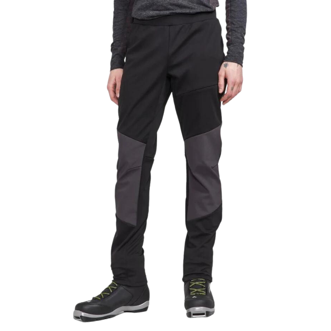 PANTALON DE SKI DE FOND CRAFT ADV BACKCOUNTRY HYBRID POUR HOMME COULEUR BLACK VU DU PANTALON NOIR PORTÉ PAR UN HOMME VU DE LA TAILLE AUX CUISSES DE FACE