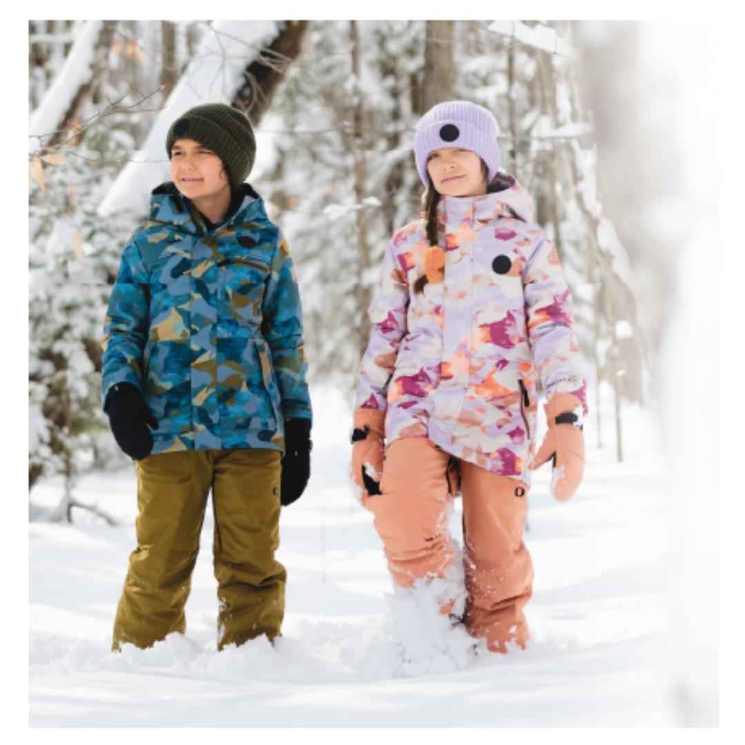 MANTEAU D'HIVER ISOLÉ DUTY NINE MADISON POUR FILLE COULEUR VIOLET VU DU MANTEAU LILAS AVC MOTIF CAMO DANS LES TONS DE FUSCHIA ORANGE ET PECHE PORTÉ PAR UNE FILLE DEHORS ACCOMPAGNÉE D'UN GARÇON AVEC LE MANTEAU mASON
