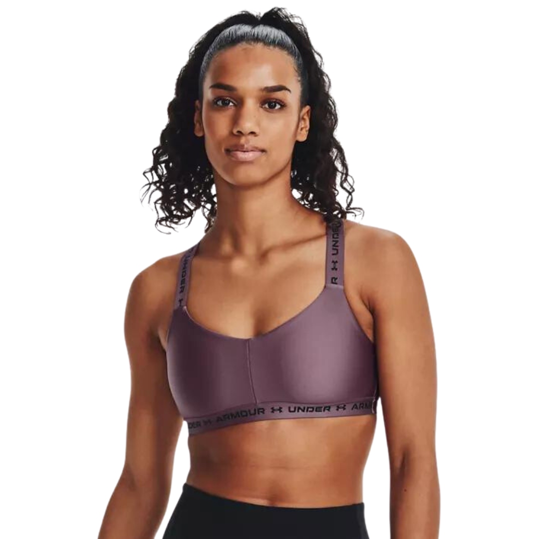 SOUTIEN GORGE DE SPORT UNDER ARMOUR UA DOS CROISÉ ET MAINTIEN LÉGER POUR FEMME couleur 500-MISTY PURPLE vu du soutien gorge mauve lettré noir porté par une femme vue de la tête à la taille de face