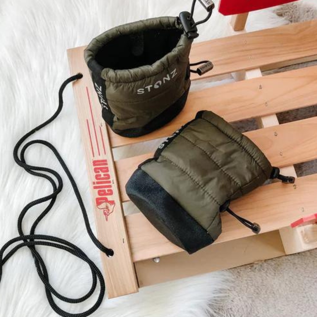 BOTTILLON STONZ PUFFER POUR BÉBÉ COULEUR PINE VU DES BOTTILLONS VERT OLIVE ET NOIR DÉPOSÉS SUR UN TRAINEAU