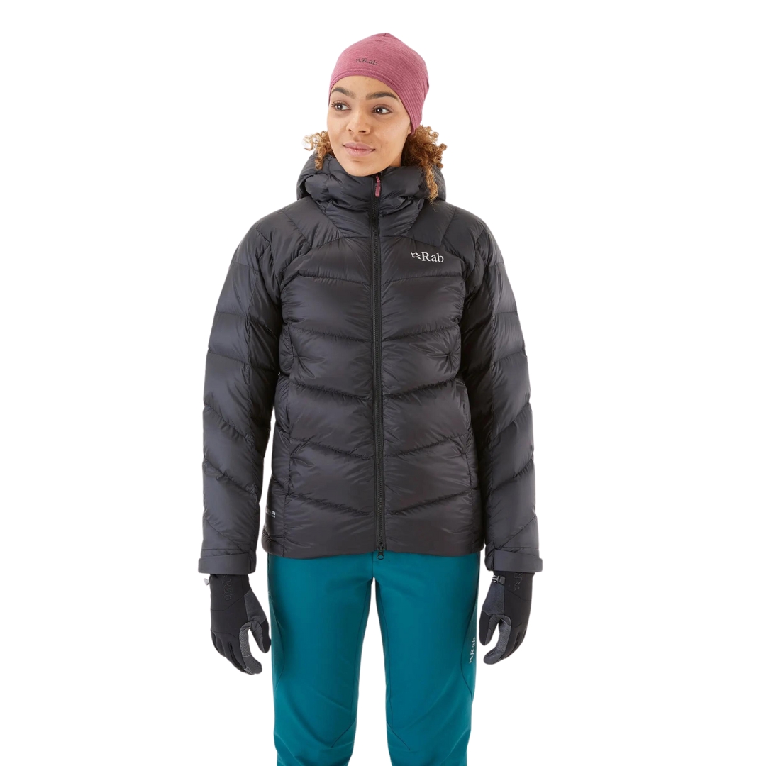 MANTEAU ISOLÉ EN DUVET RAB NEUTRINO PRO POUR FEMME COULEUR Anthracite VU DU MANTEAU GRIS TRÈS FONCÉ AVEC DÉTAIL ROUGE BOURGOGNE PORTÉ PAR UNE FEMME VUE DE FACE