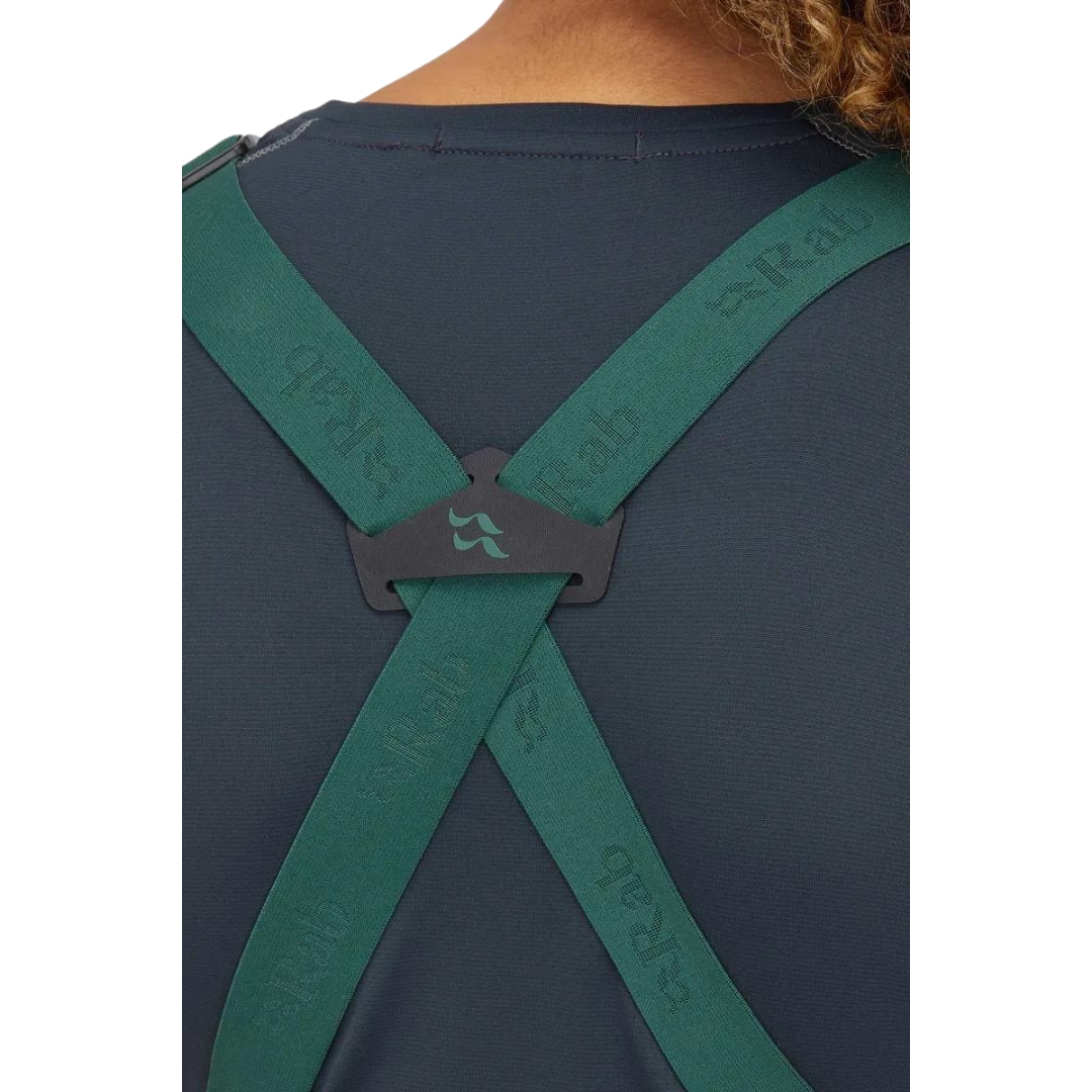 SALOPETTE IMPERMÉABLE DE SKI RAB KHROMA KINETIC POUR FEMME couleur green slate portée par une femme vue en gros plan sur le croisement des bretelles au dos
