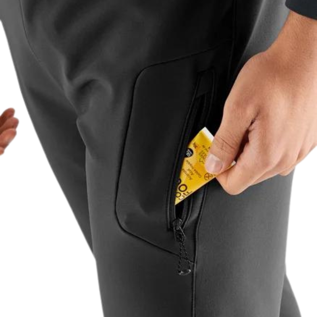 PANTALON DE NEIGE SALOMON RS WARM SOFTSHELL POUR HOMME couleur deep black vu du pantalon noir porté par un homme qui met un objet dans la poche de cuisse
