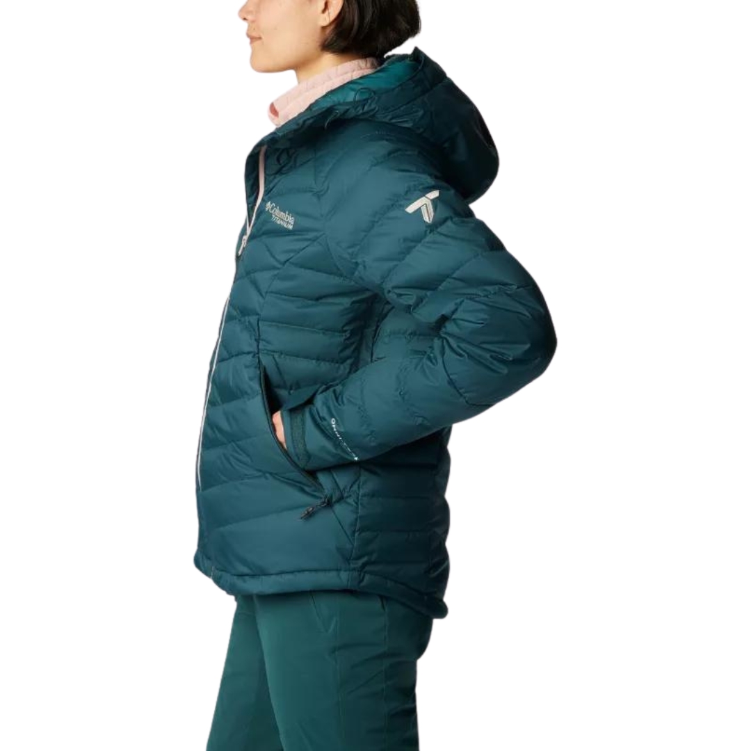MANTEAU DE SKI ALPIN ISOLÉ EN DUVET COLUMBIA DROARING FORK POUR FEMME couleur 414-NIGHT WAVE vu du manteau turquoise foncé avec fermeture éclair rose pale porté par une femme vue de profil gauche une main dans la poche latérale