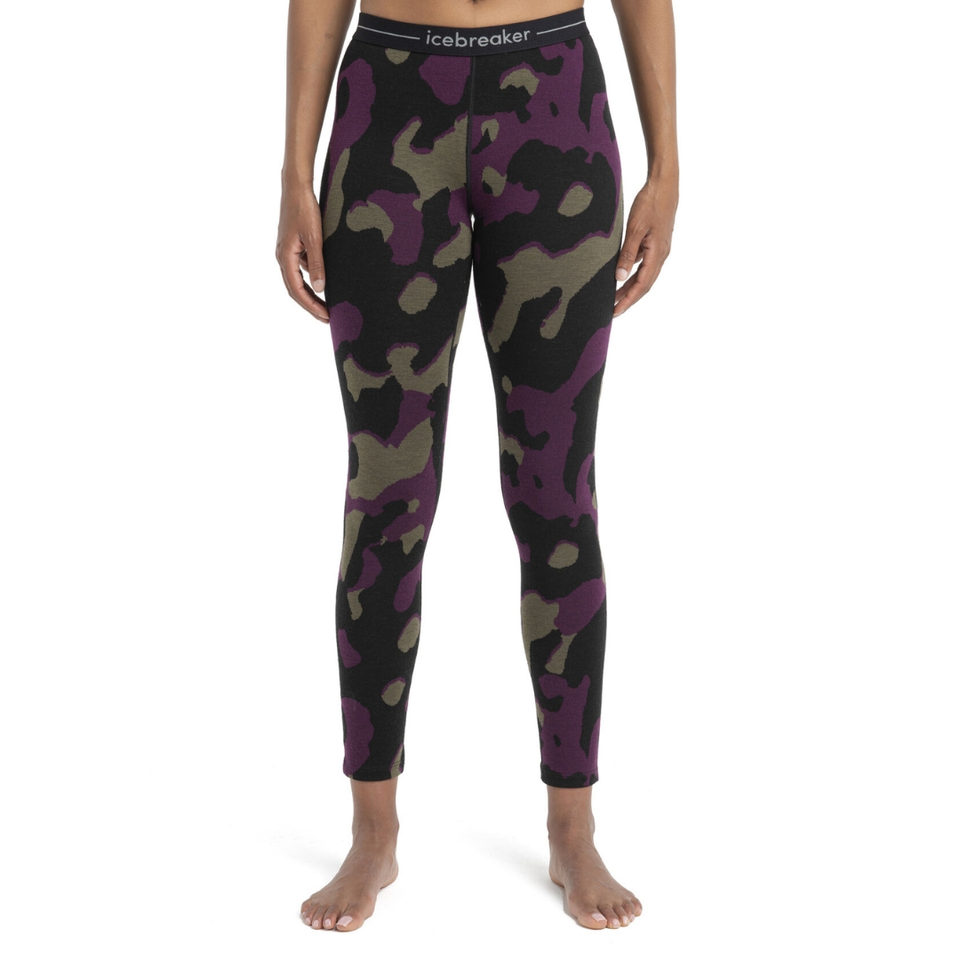 LEGGING COUCHE DE BASE ICEBREAKER 260 VERTEX NATURAL SHADE EN MÉRINO POUR FEMME couleur 962-BLACK/LODEN/NIGHTSHADE vu du legging noir avec motif en tache violet et khaki porté par une femme vue de la taille aux pieds de face