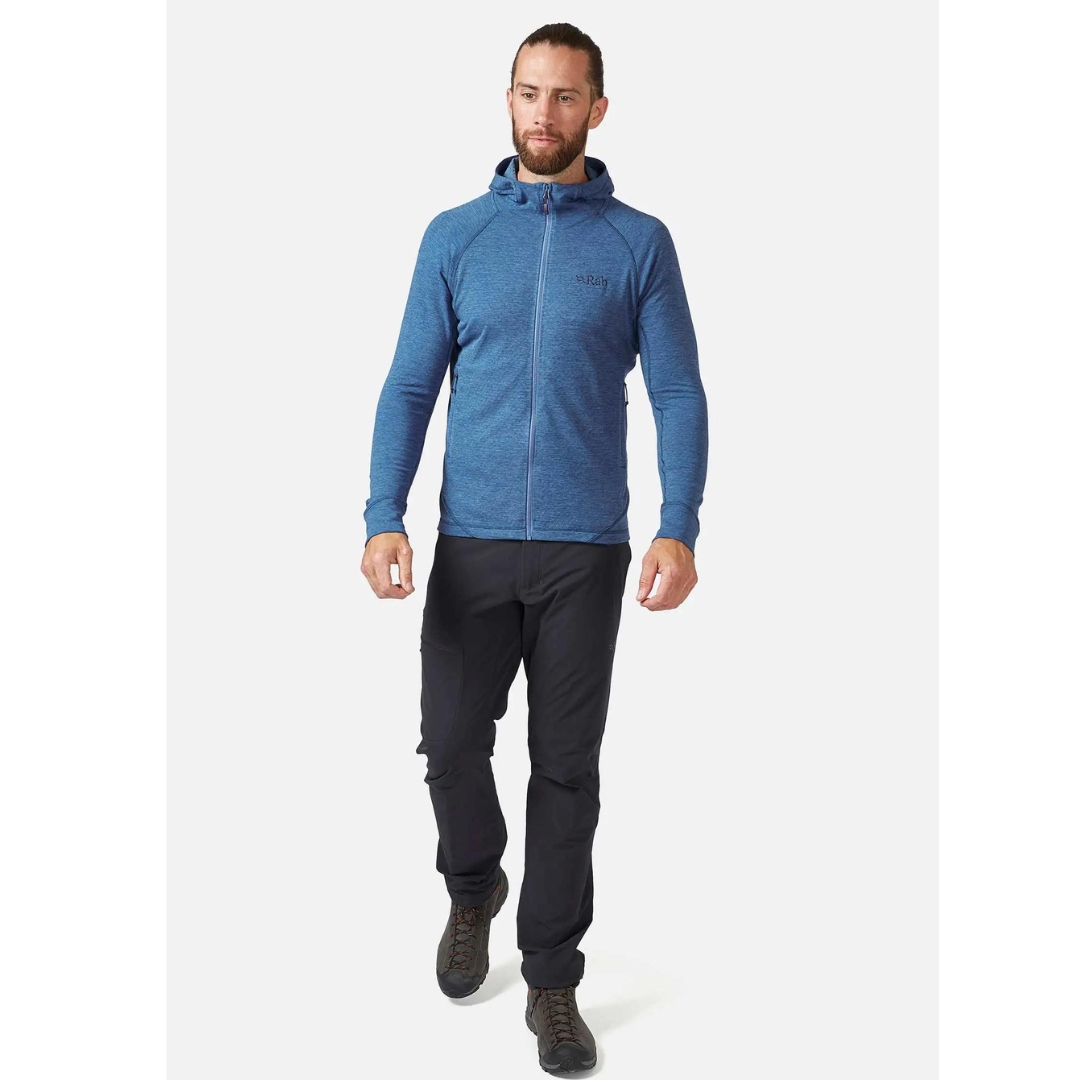 CHANDAIL À CAPUCHON RAB NEXUS POUR HOMME COULEUR DEMIN PORTÉ PAR UN HOMME VU DE LA TÊTE AUX PIEDS DE FACE CHANDAIL BLEU AJUSTÉ QUI TOME A LA MI-HANCHE