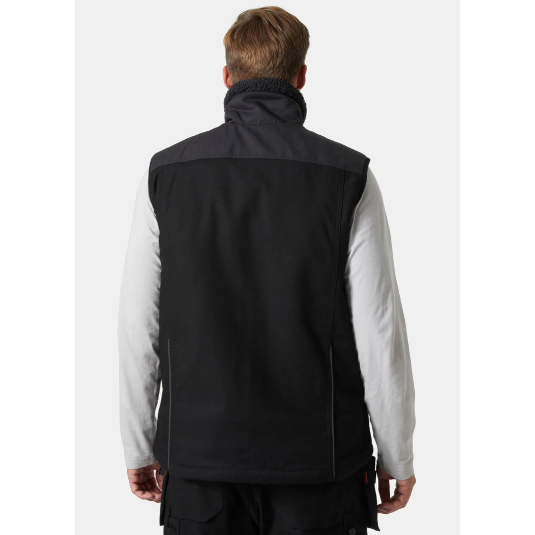 VESTE DE TRAVAIL DOUBLÉE SANS MANCHE HELLY HANSEN WORKWEAR OXFORD couleur black/ebony porté par un homme vu de dos veste entièrement noire à l'arrière on voit les deux textures des matières