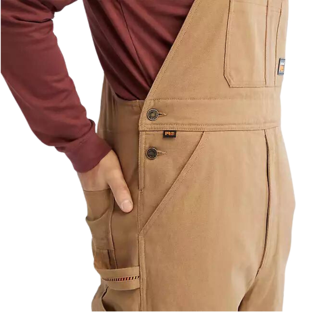 salopette isolée timberland gritman pour homme couleur dark wheat vu de la salopette brune/beige portée par un homme vu en gros plan sur la hanche droite de profil droit