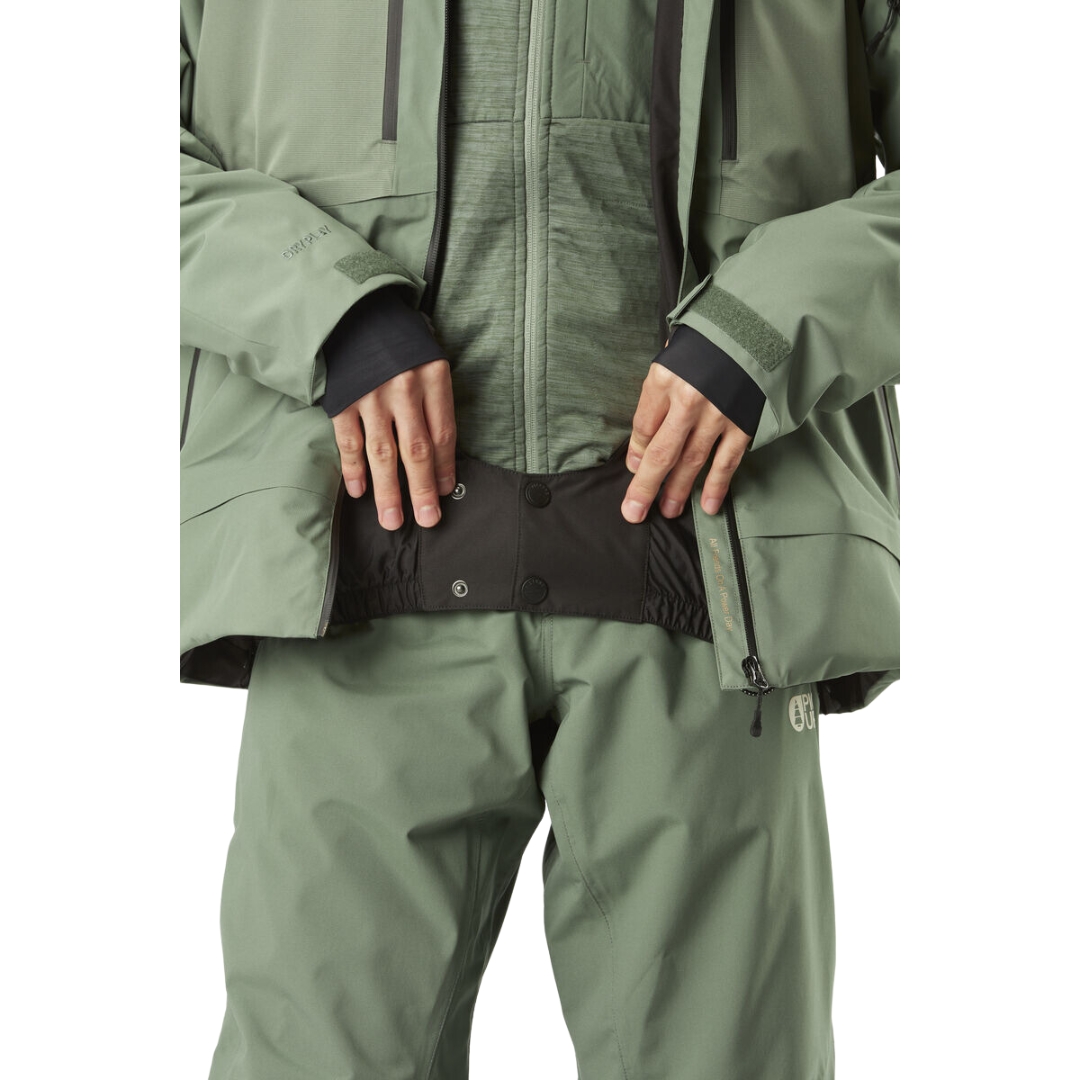 MANTEAU DE SKI PICTURE GOODS POUR HOMME couleur LAUREL WREATH vu du manteau vert tendre porté par un homme qui montre la jupe par neige