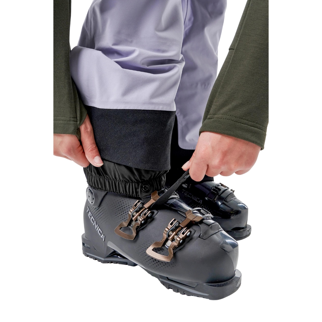 SALOPETTE COQUILLE DE SKI ALPIN ORAGE MTN-X CLIFF POUR FEMME porté par une femme qui montre le bas de la salopette à fermeture éclair sur le bas pour les chaussures