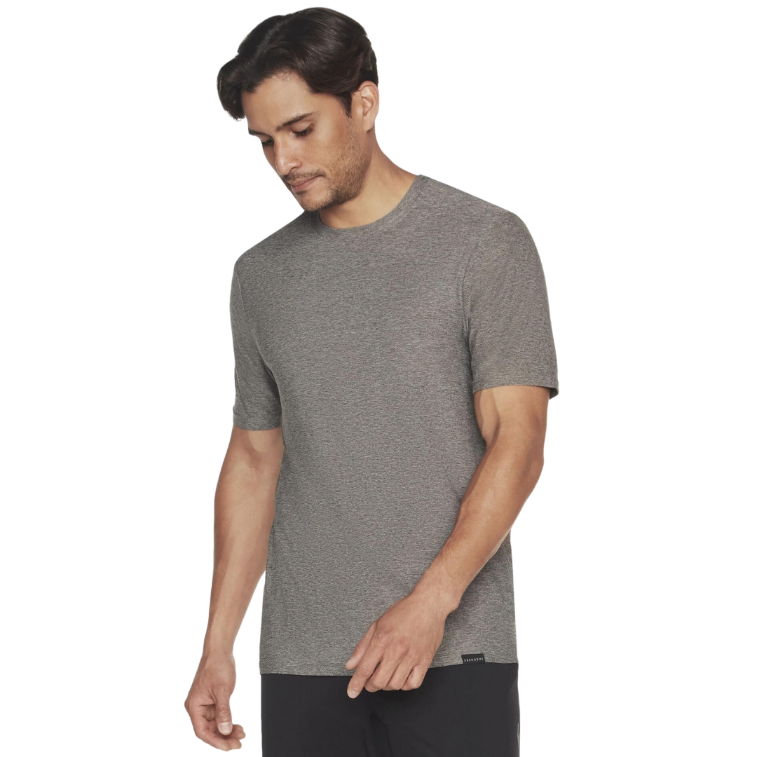 T-SHIRT MANCHES COURTES SKECHERS GO DRI ALL DAY POUR HOMME couleur asphalt vu du chandail gris chiné porté par un homme vu de la tête aux cuisses de face